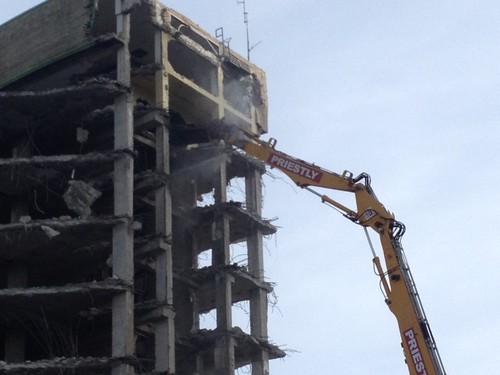 Dynaset Dust Suppression System spraying from a shear attachment at a demolition site