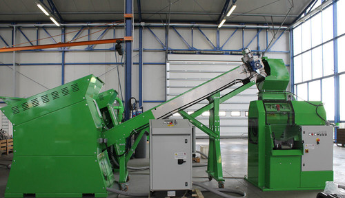 Green wire shredder machine feeding scrap wire to a green wire recycling system