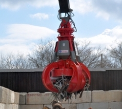 red scrap grapple with magnet moving scrap metal