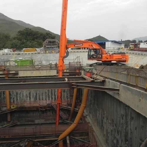 orange excavator with long telescopic teledipper arm attached to it doing very deep excavation work